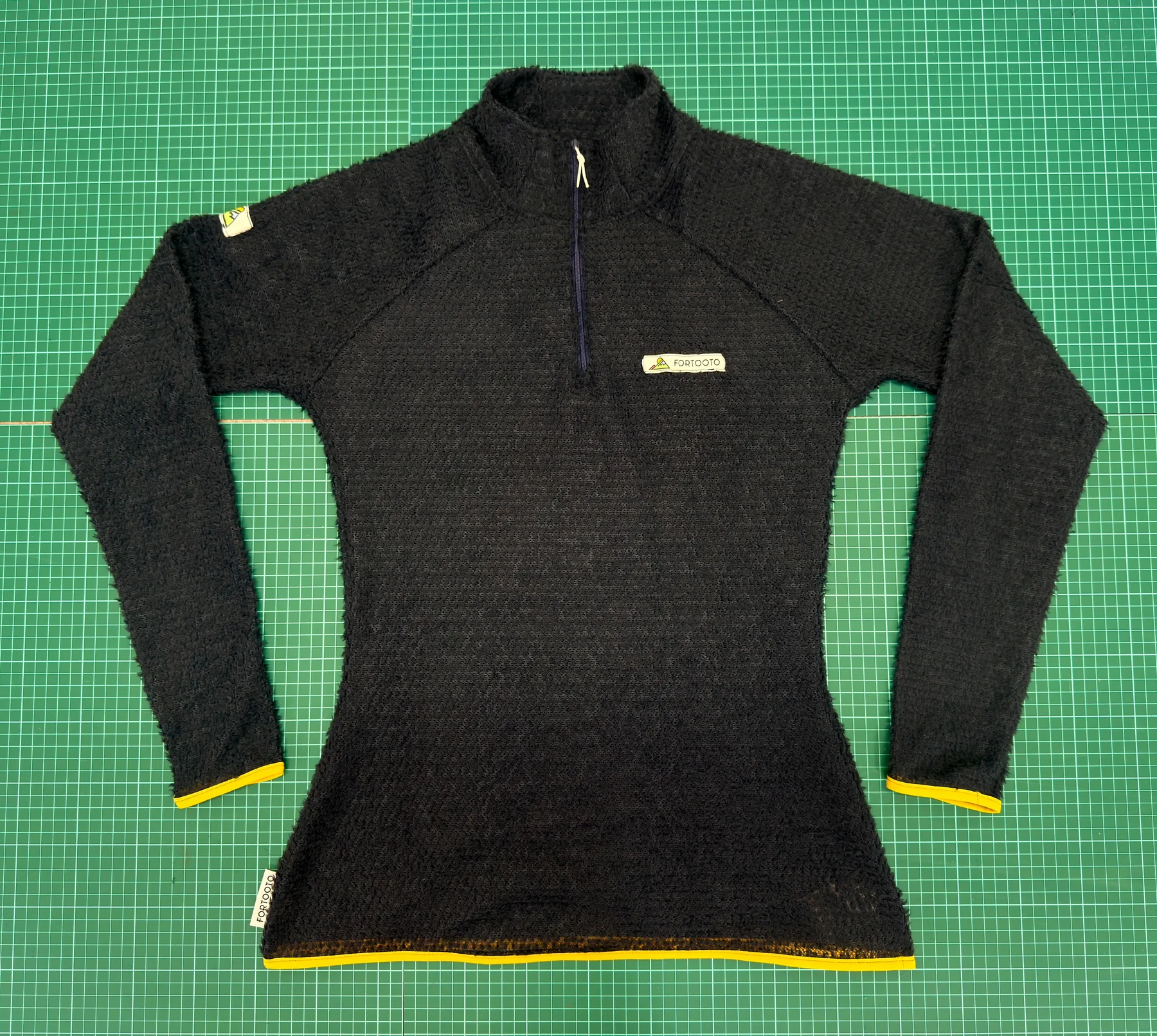 Sparks Alpha 60 quarter zip pullover laid flat on a cutting mat